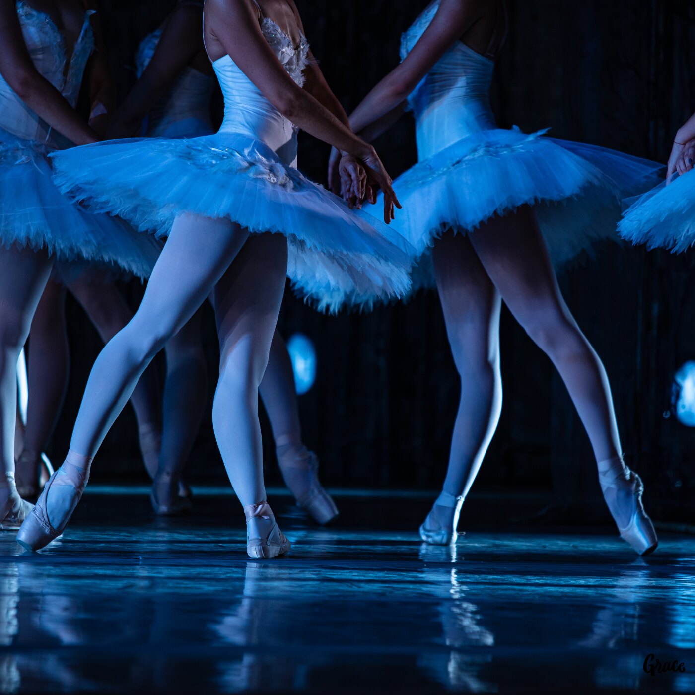 Ballet dancers performing under blue stage lights
